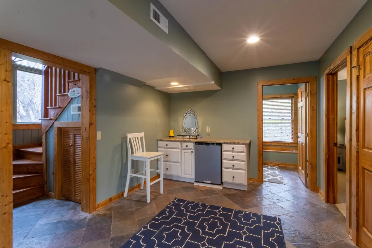 A cozy kitchenette area with a staircase, mirror, and inviting seating that suggests a self-contained apartment or guest suite. The space allows for morning coffee, evening gatherings, or quiet moments away from the main house.