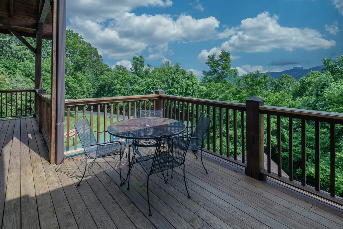 An alfresco dining table sits under open skies, surrounded by lush greenery and mountain vistas. The space is arranged for outdoor dining and group gatherings, with the golden hour sunlight illuminating the setting. The table is perfect for shared meals, cocktails, and wellness-focused gatherings.